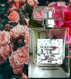 A clear glass bottle of De La Fontaine Rose & Bergamot Eau de Toilette with a white label, cap, and pink floral background.